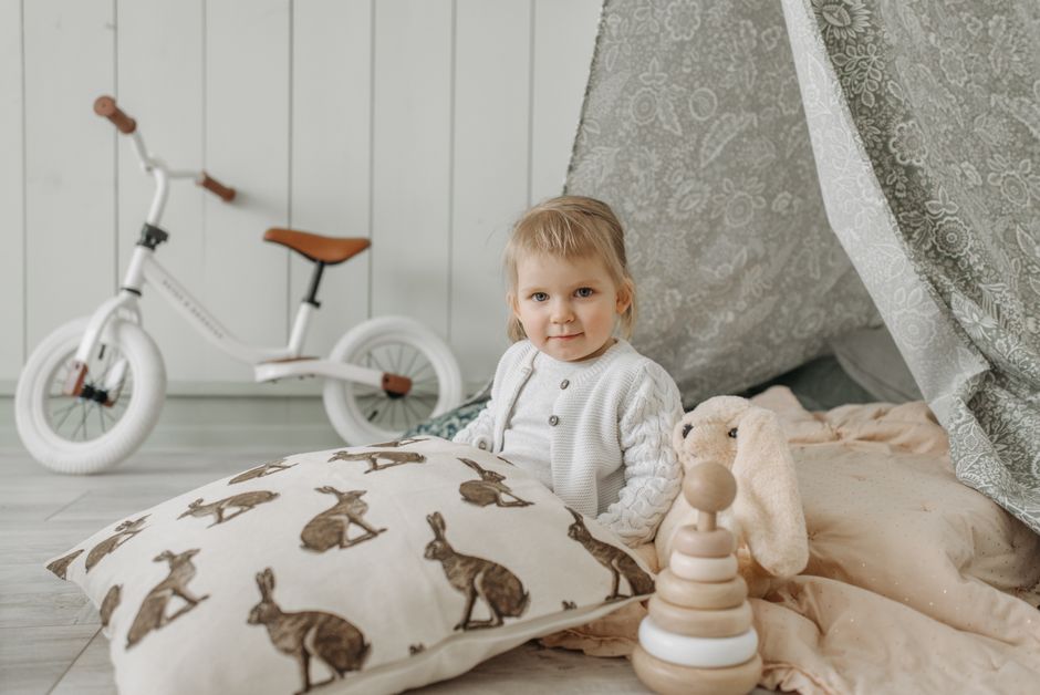 Lit enfant en bois avec coussins colorés.